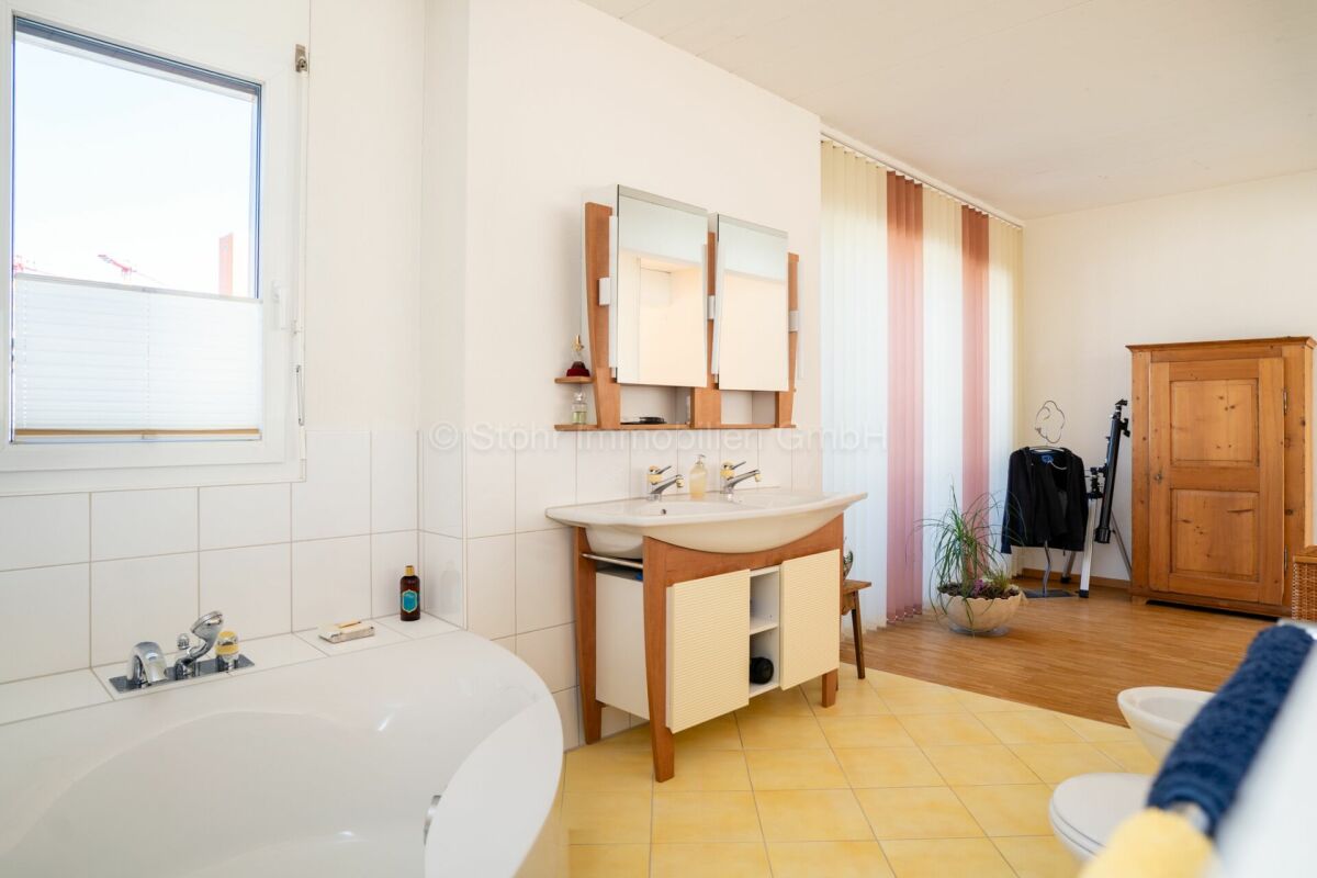 Helles Badezimmer mit Holzmöbeln