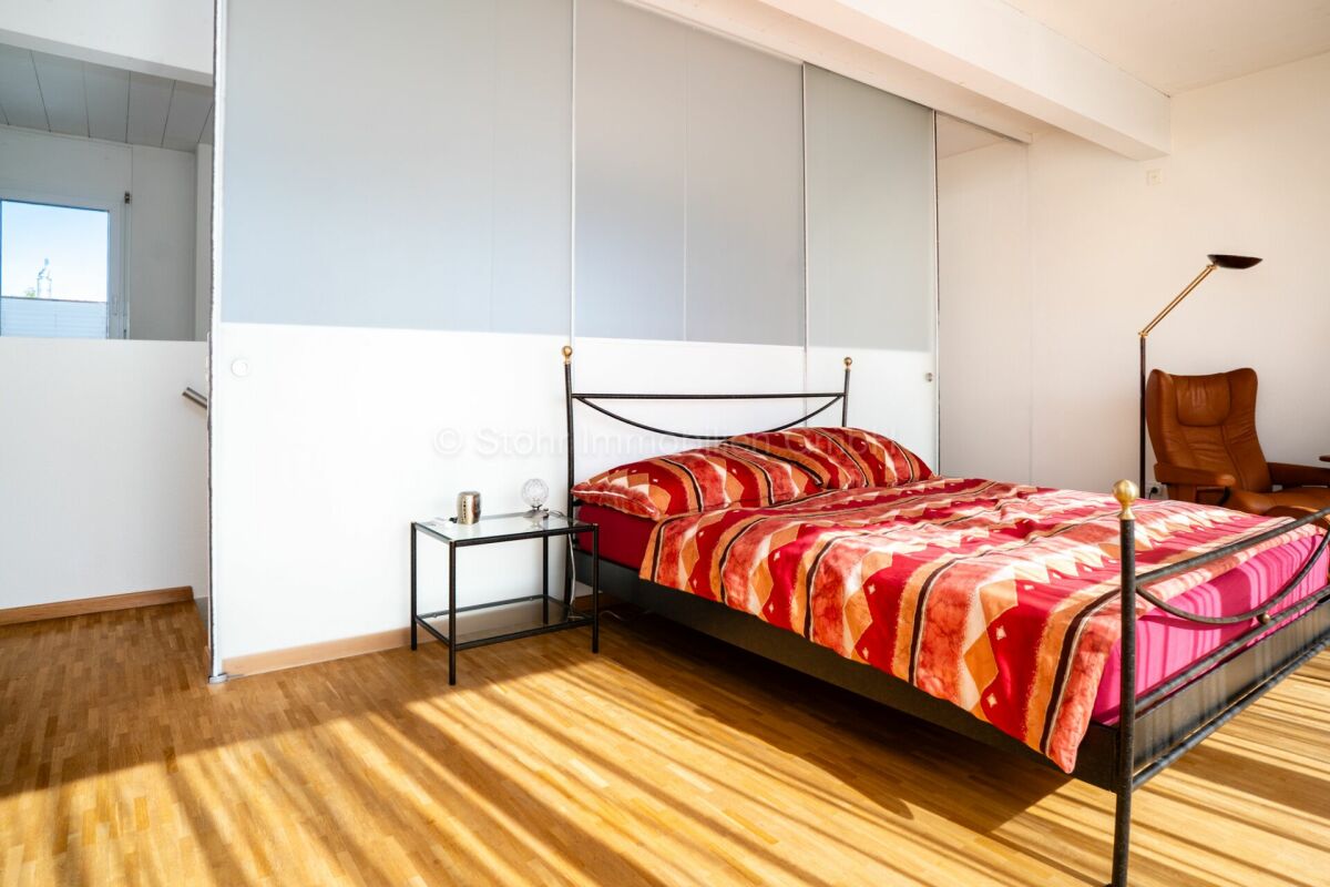 Schlafzimmer mit Metallbett und großer Schrankfront