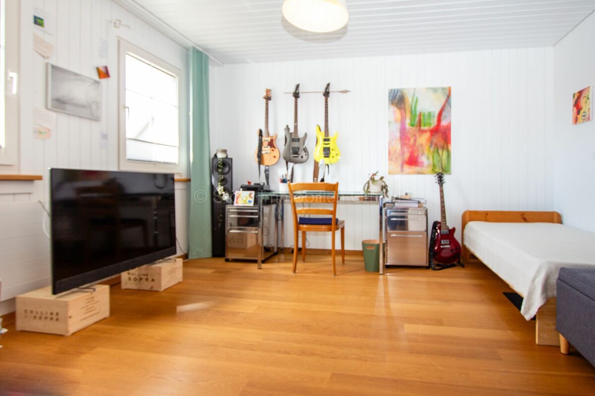 Hell eingerichtetes Schlafzimmer mit Musikecke