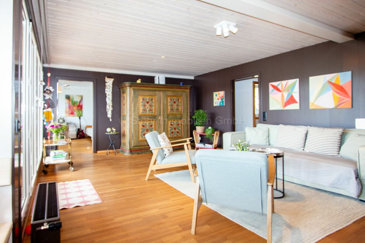 Gemütliches Wohnzimmer mit dunklen Wänden und Holzdecke