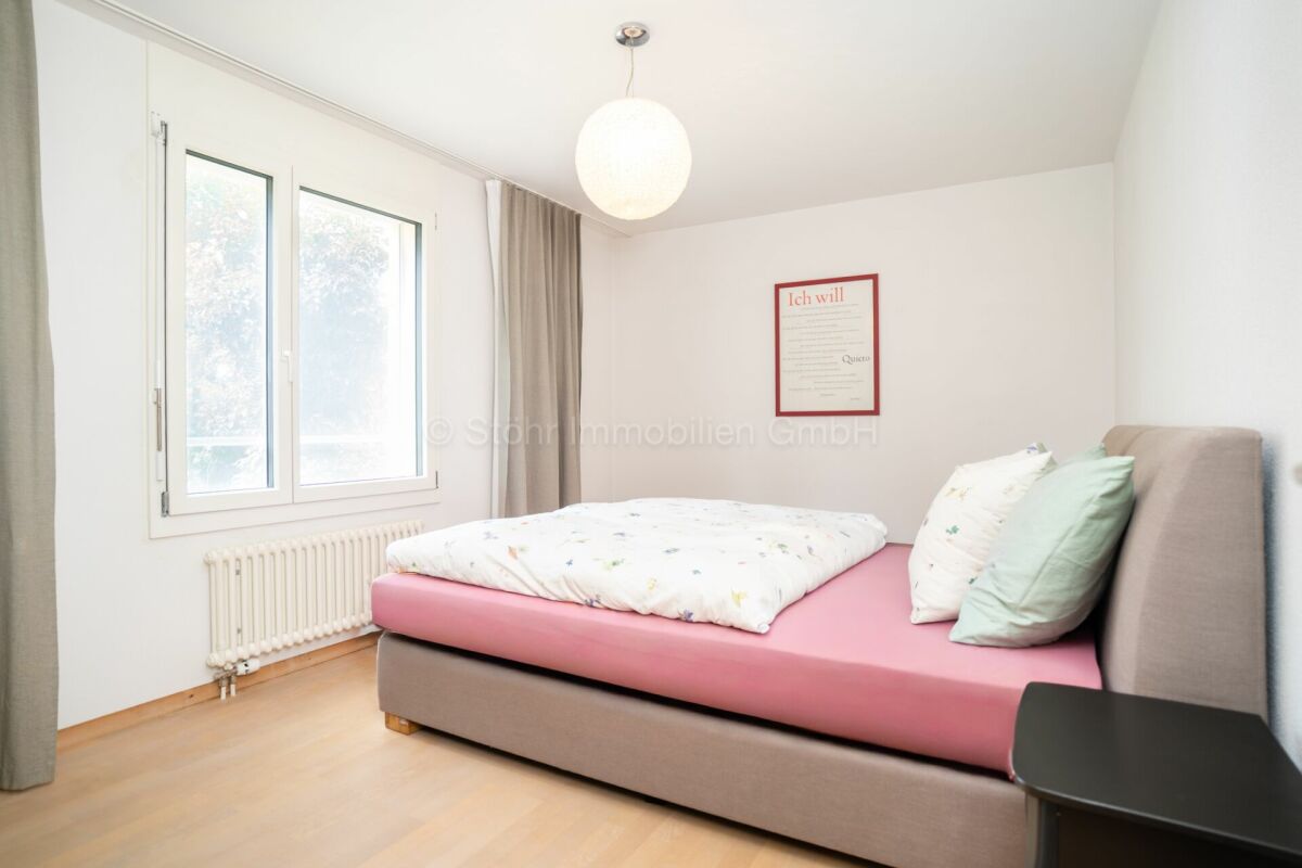 Helles Schlafzimmer mit Einzelbett und Fenster
