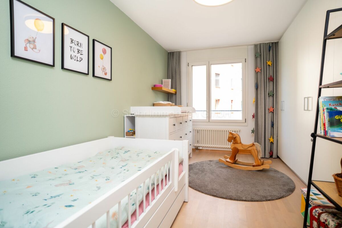 Helles Kinderzimmer mit Einzelbett und Spielbereich