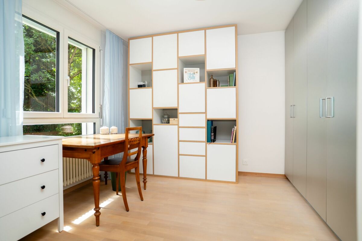 Helles Arbeits- bzw. Schlafzimmer mit großem Fenster und Einbauschränken