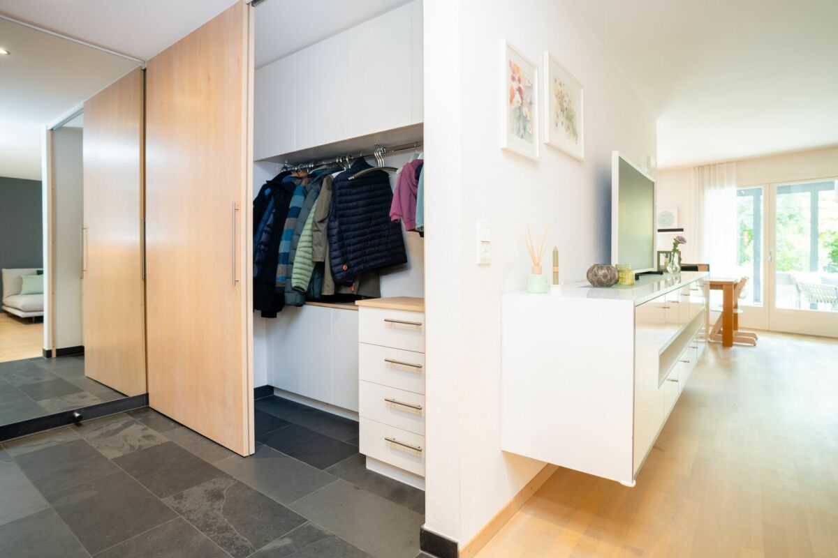 Heller Eingangsbereich mit Garderobe und Wohnblick