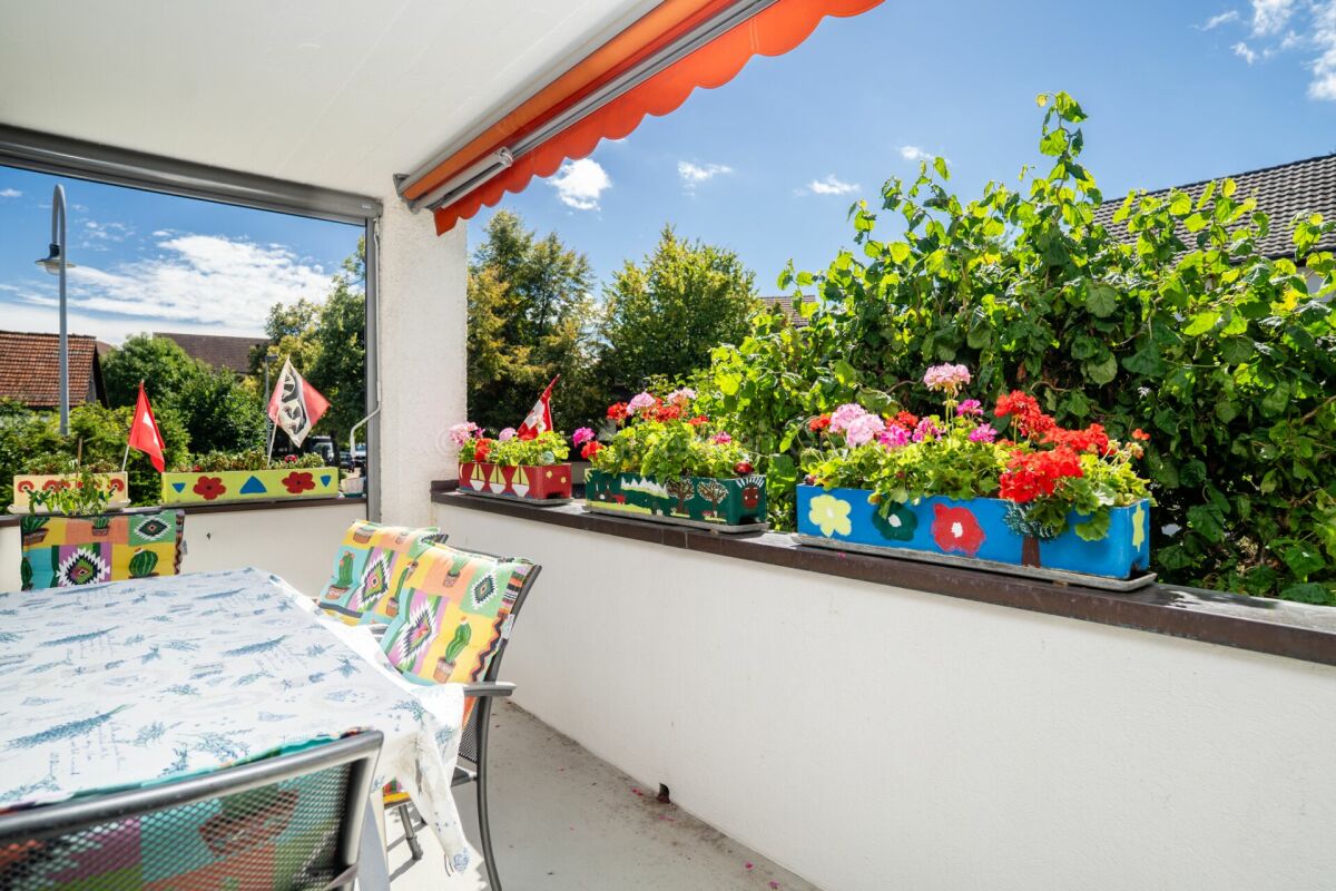 Bunter Balkon mit Blumenkästen und Sitzplatz
