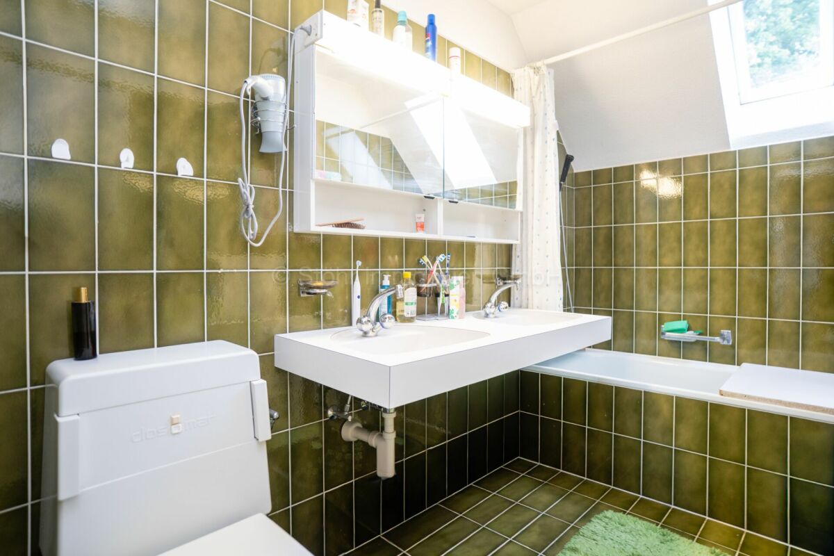 Badezimmer mit grün gefliesten Wänden