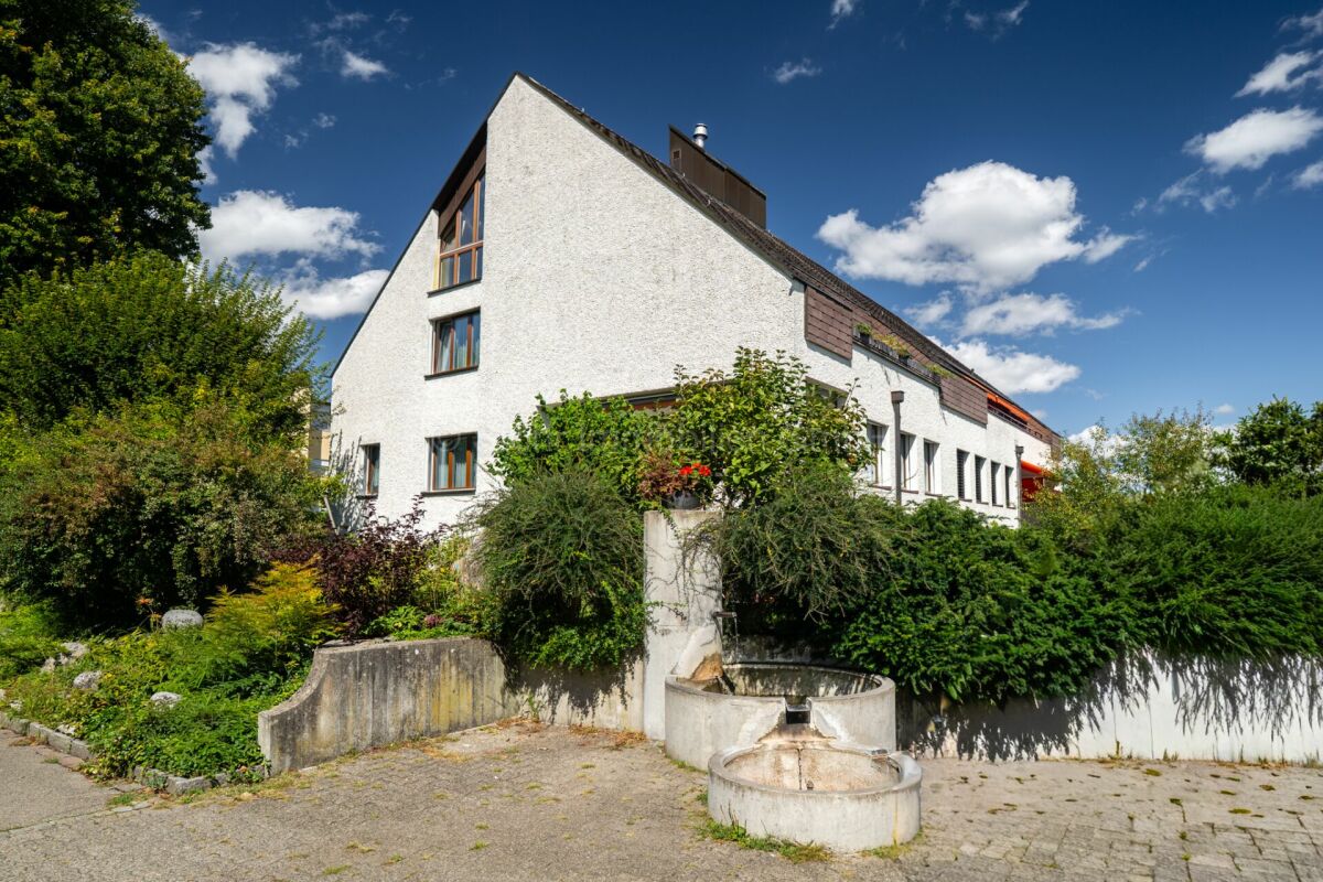 Weiße Wohnhausfassade mit Garten