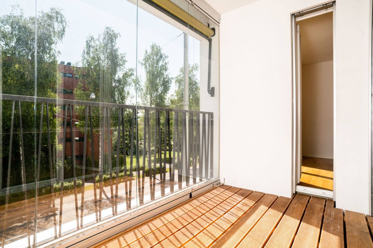Balkon mit großem Fenster und Blick ins Grüne