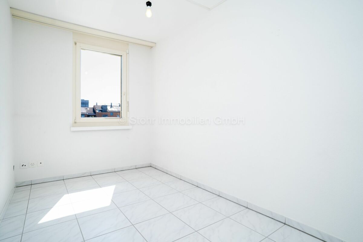 Leeres helles Zimmer mit Fliesenboden und Fenster