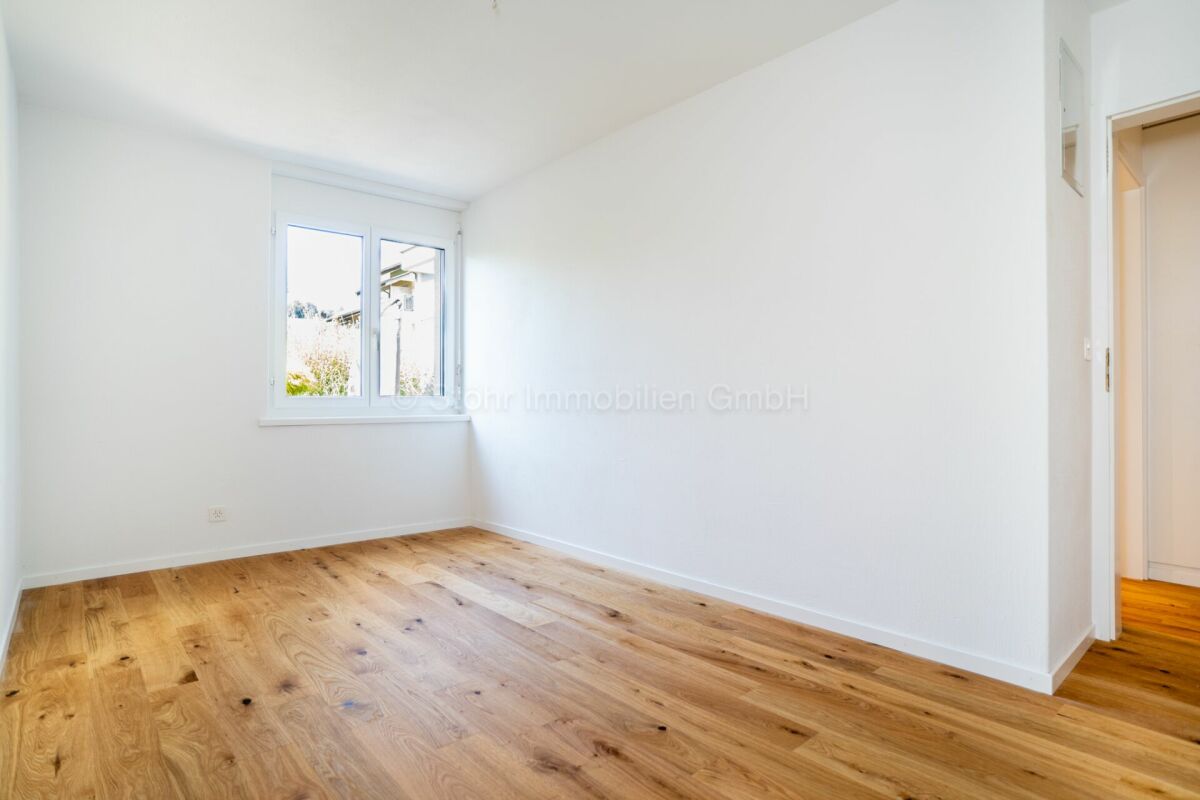 Helles leeres Zimmer mit Parkett und Fenster