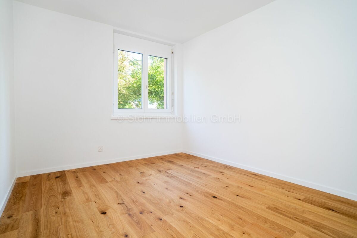 Heller leerer Raum mit Holzfußboden und Fenster