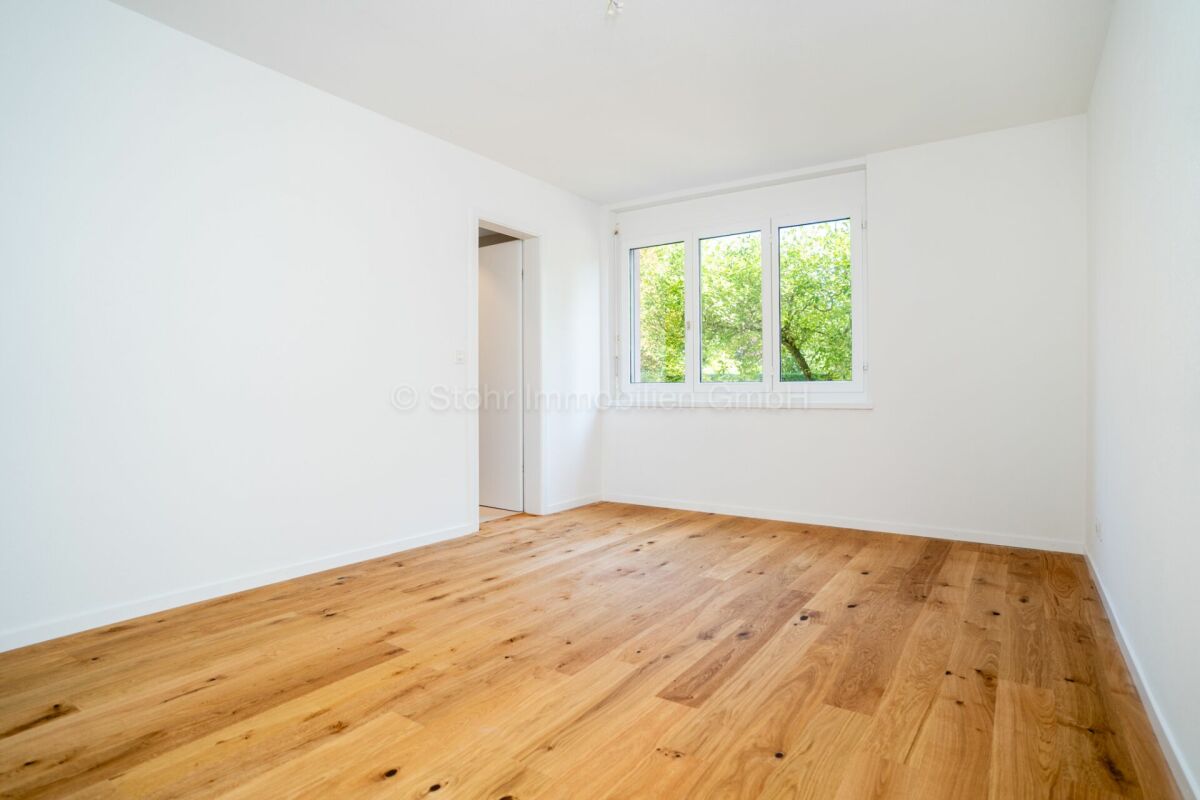 Helles, leeres Zimmer mit Holzfußboden