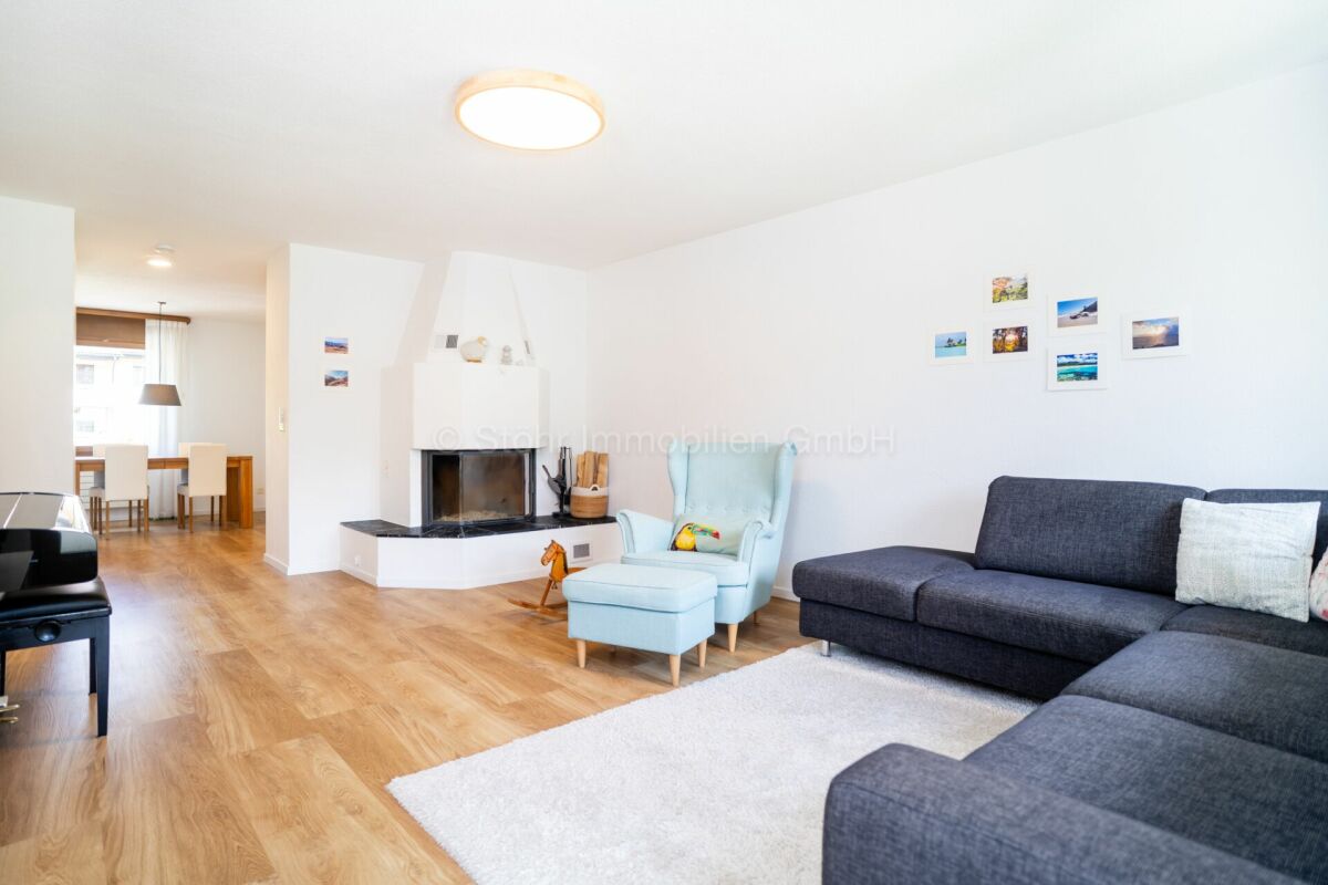 Helles Wohnzimmer mit Kamin und offenem Essbereich
