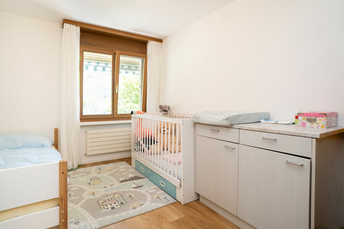 Kinderzimmer mit Bett, Kinderbett und Wickelkommode