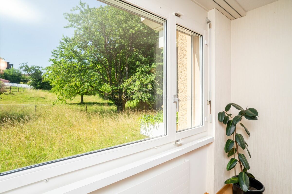 Heller Raum mit großem Fenster und Gartenblick