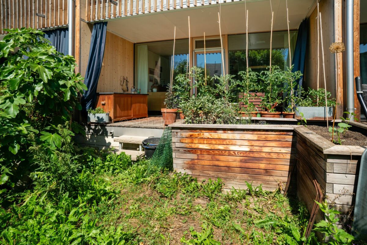 Garten mit überdachter Terrasse und Pflanzbeeten