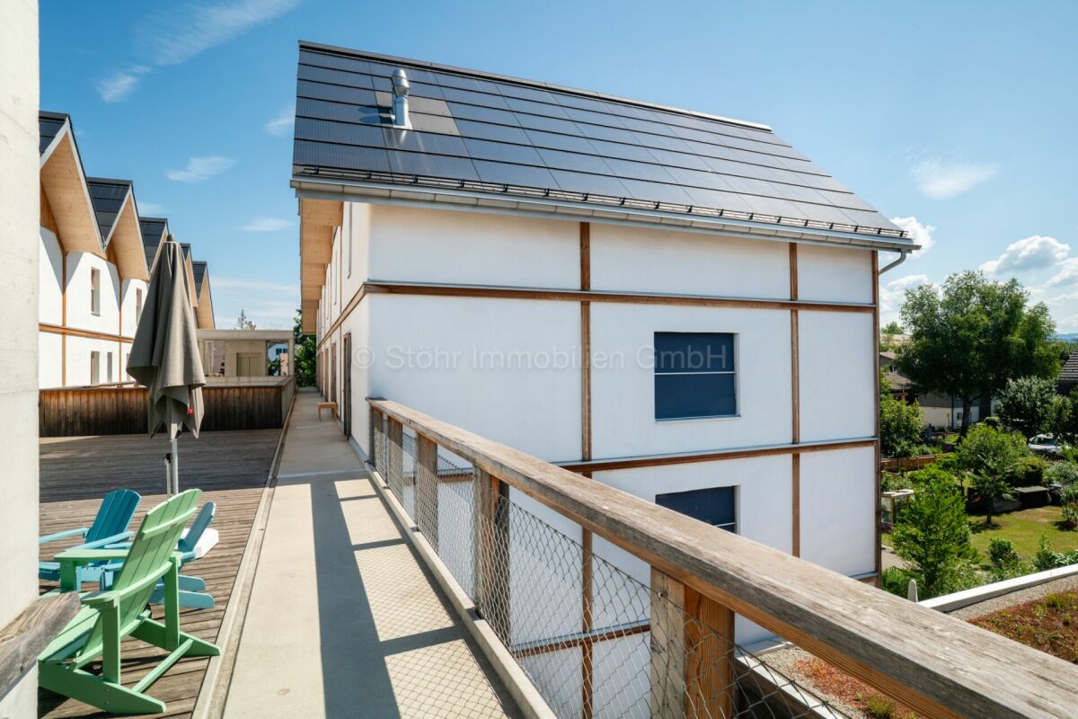 Dachterrasse mit Holzgeländer und Blick auf moderne Wohnhäuser