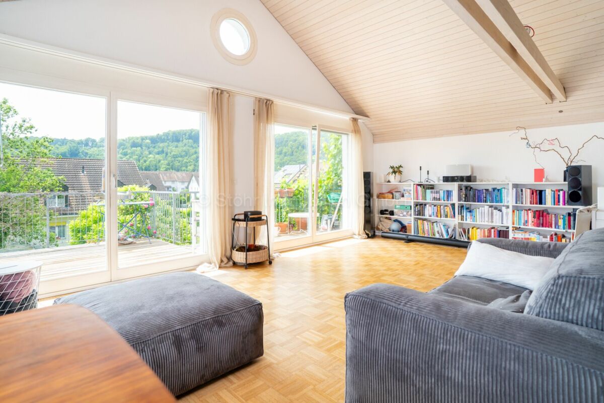 Helles Dachgeschoss-Wohnzimmer mit Balkonblick