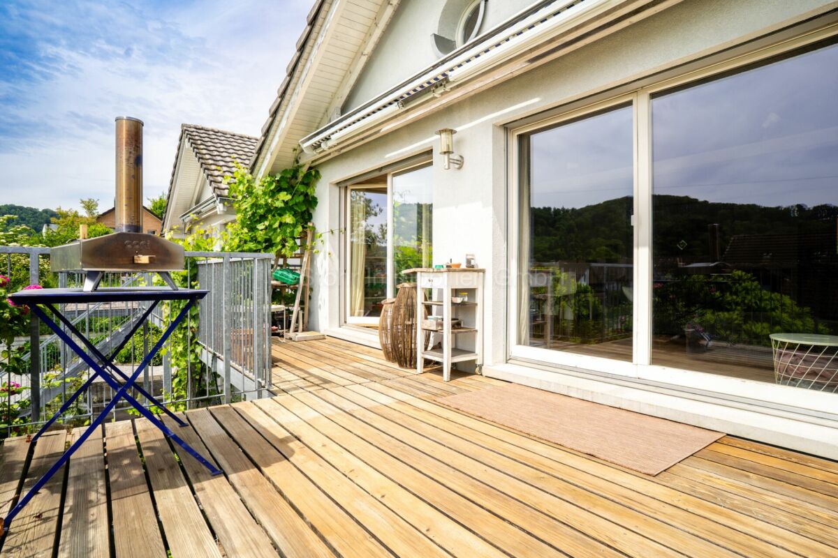 Terrasse mit Holzdeck und großem Schiebefenster