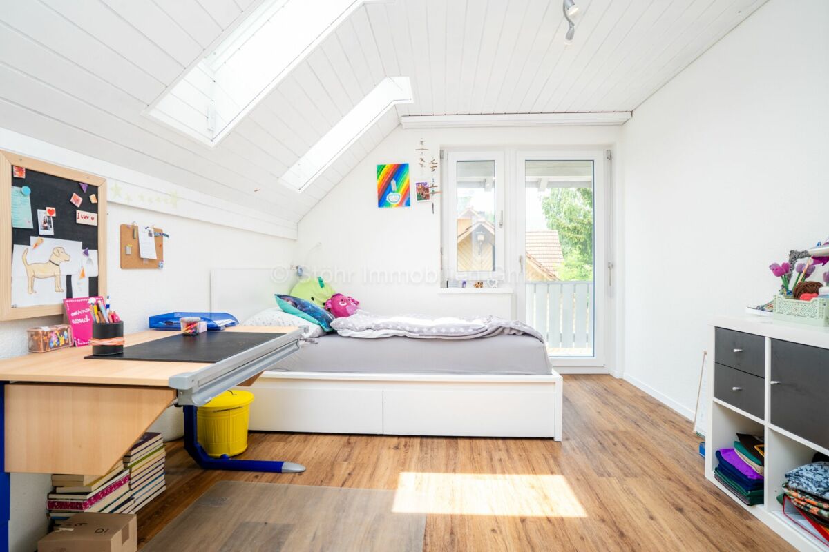 Helles Dachzimmer mit Schlafbereich und Arbeitszone