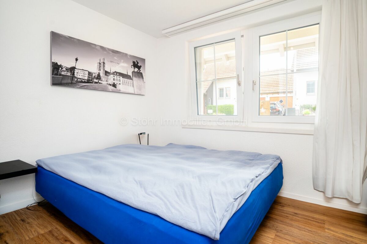 Helles Schlafzimmer mit Doppelbett und Fenster