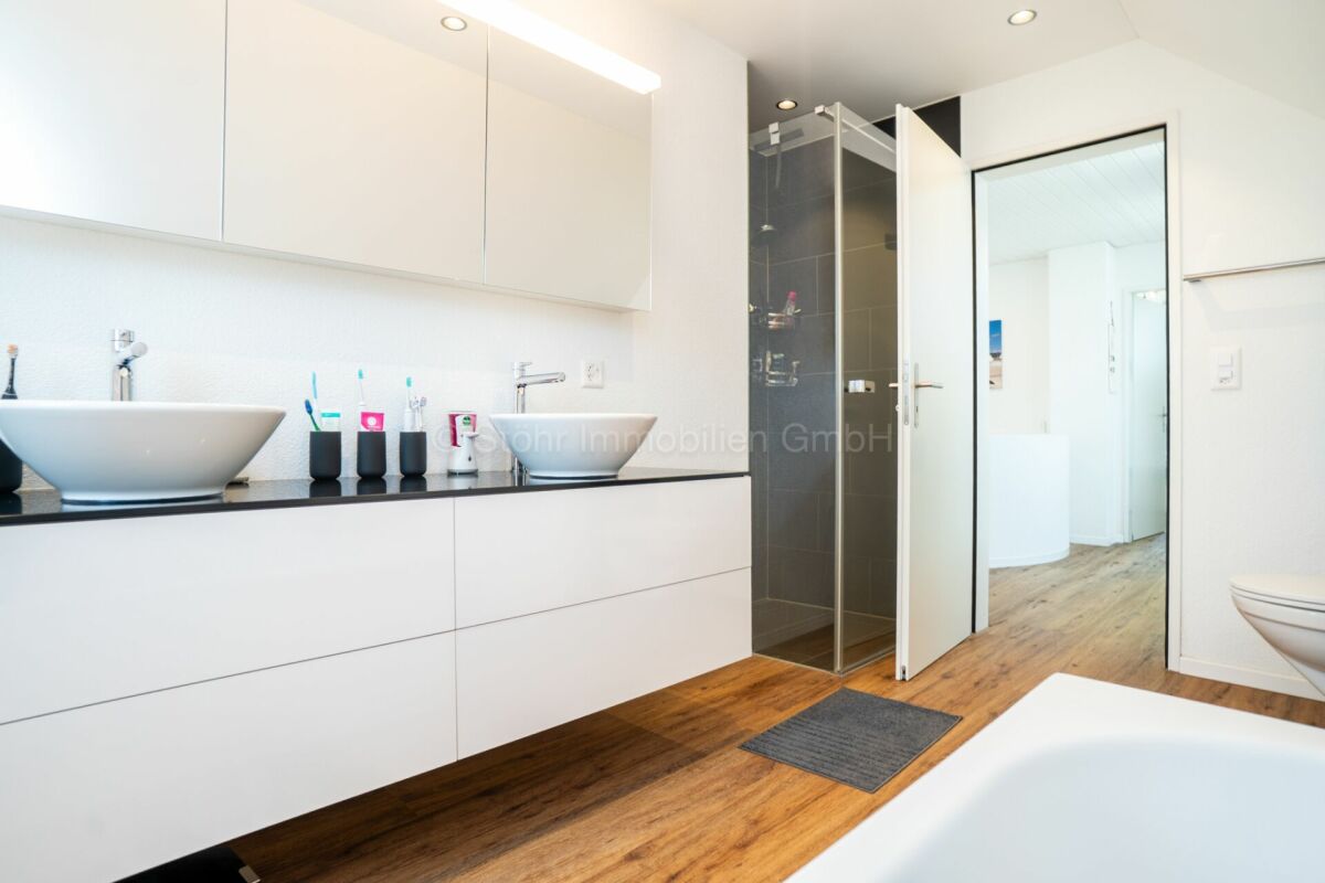 Modernes Badezimmer mit Doppelwaschtisch und Duschkabine