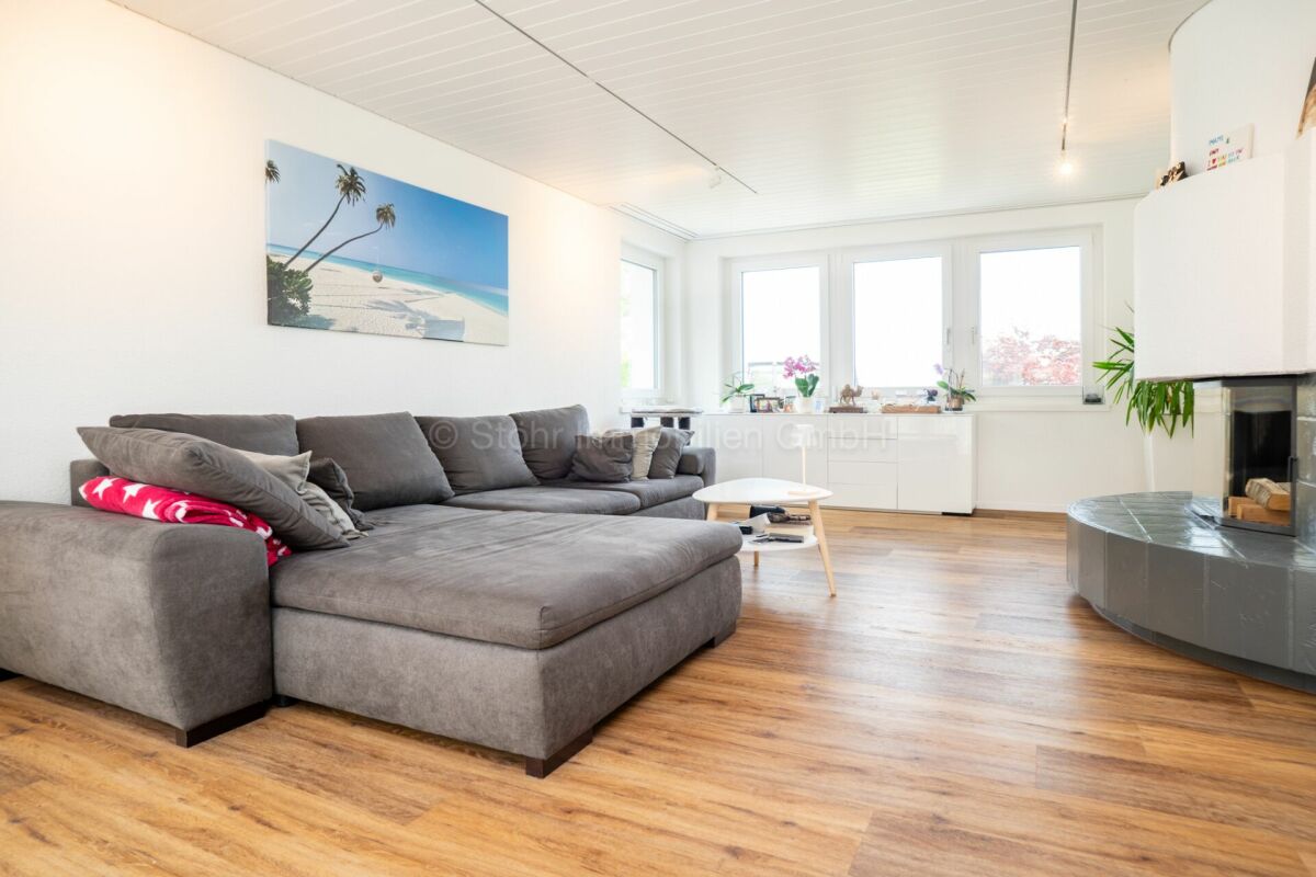 Wohnzimmer mit großem Sofa und Kamin