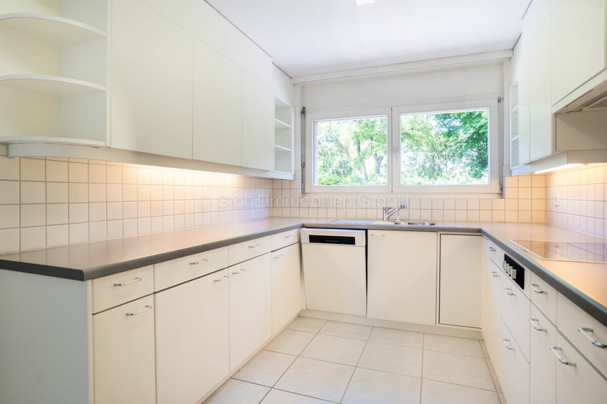 Weiße Einbauküche mit Fensterblick