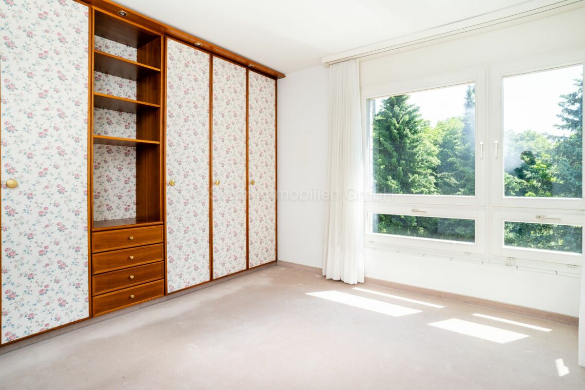 Helles Schlafzimmer mit Einbauschrank und großem Fenster