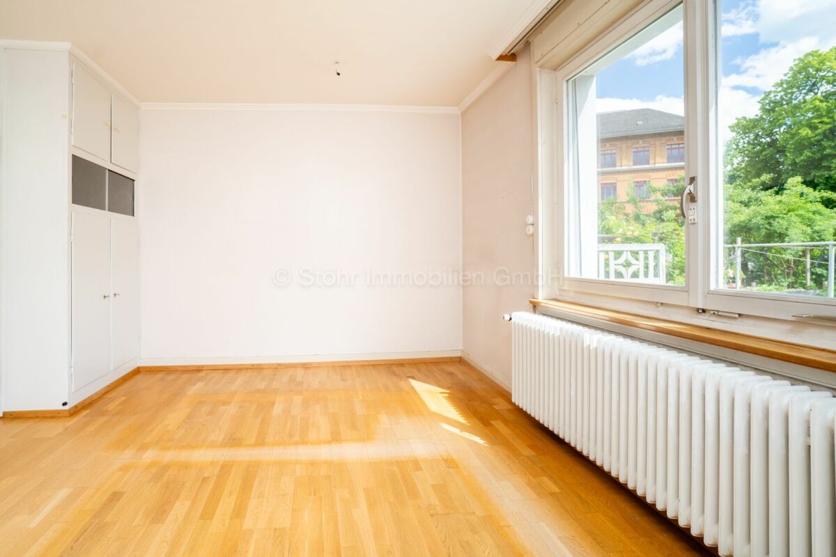 Helles leeres Zimmer mit Fenster und Heizkörper