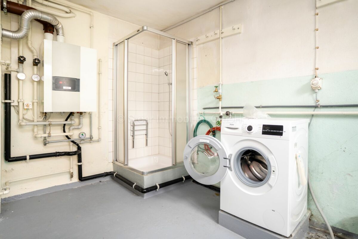 Hauswirtschafts- und Technikraum mit Dusche und Waschmaschine