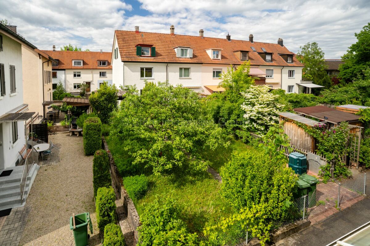 Blick auf einen begrünten Innenhof zwischen Wohnhäusern
