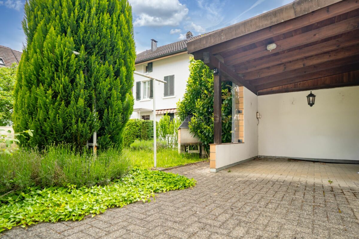 Überdachte Einfahrt mit Garten und Wohnhaus