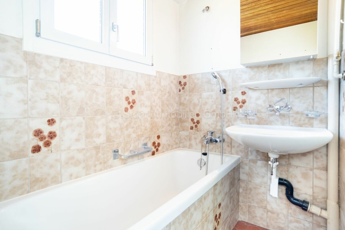 Kleines Badezimmer mit Badewanne und Waschbecken