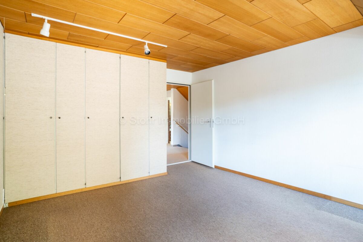 Helles Zimmer mit Holzdecke und Einbauschrank
