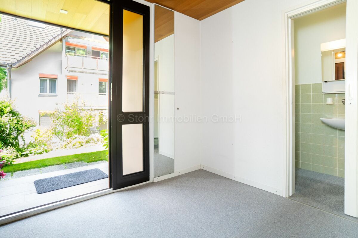 Heller Eingangsraum mit Blick ins Freie und angrenzendem Bad