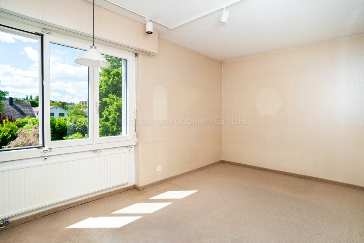 Helles, leeres Zimmer mit großem Fenster