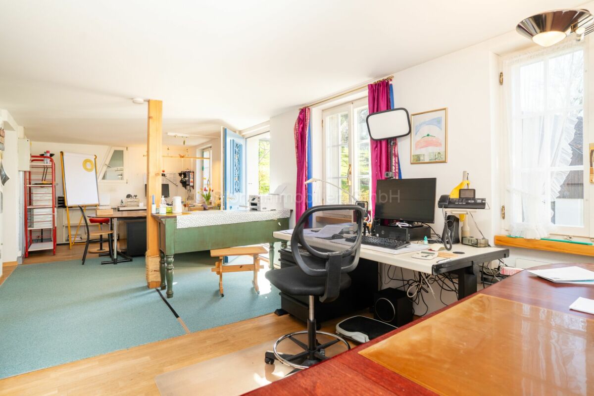 Helles Arbeits- und Wohnzimmer mit improvisiertem Bürobereich