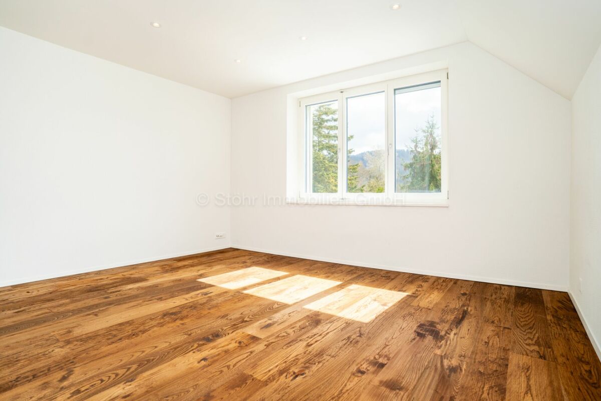 Leeres, helles Zimmer mit Holzboden