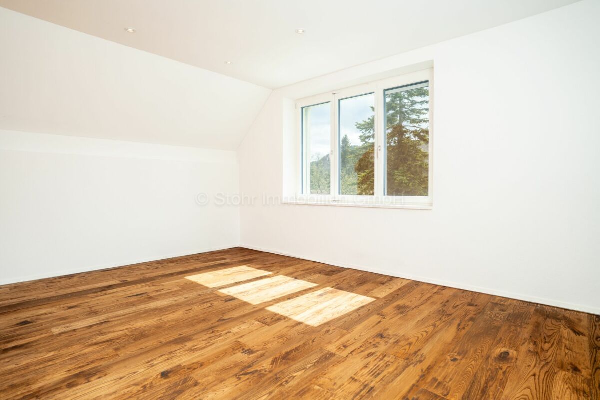Heller leerer Raum mit Holzfußboden und Fenster