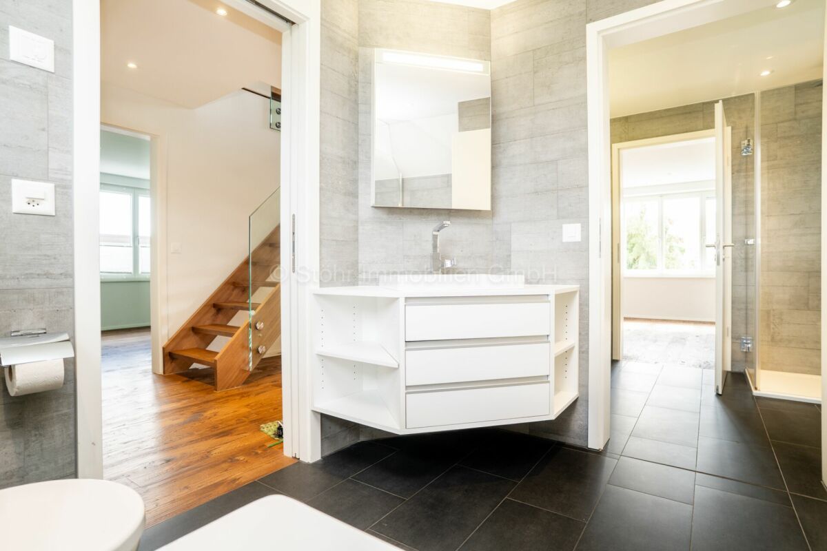 Modernes Badezimmer mit angrenzendem Flur und Treppenbereich