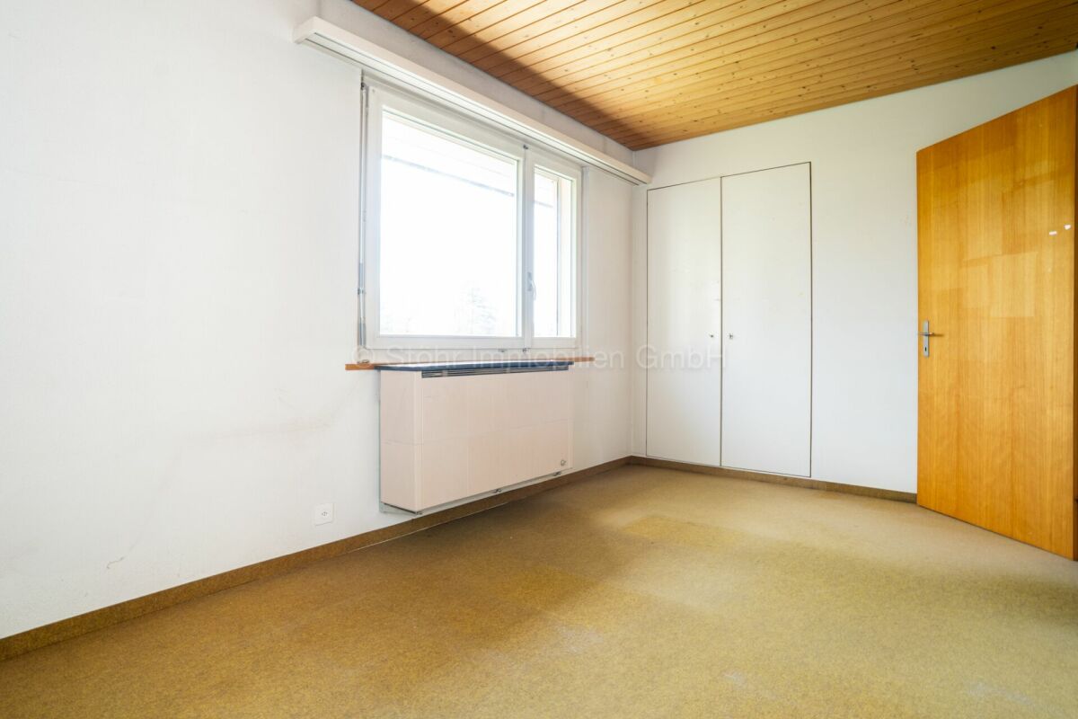 Leeres Zimmer mit Holzdecke und Einbauschrank