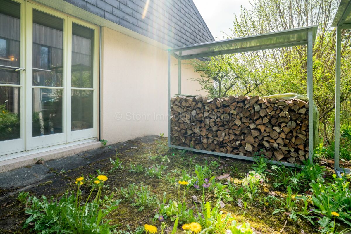 Gartenbereich neben dem Haus mit Holzlager