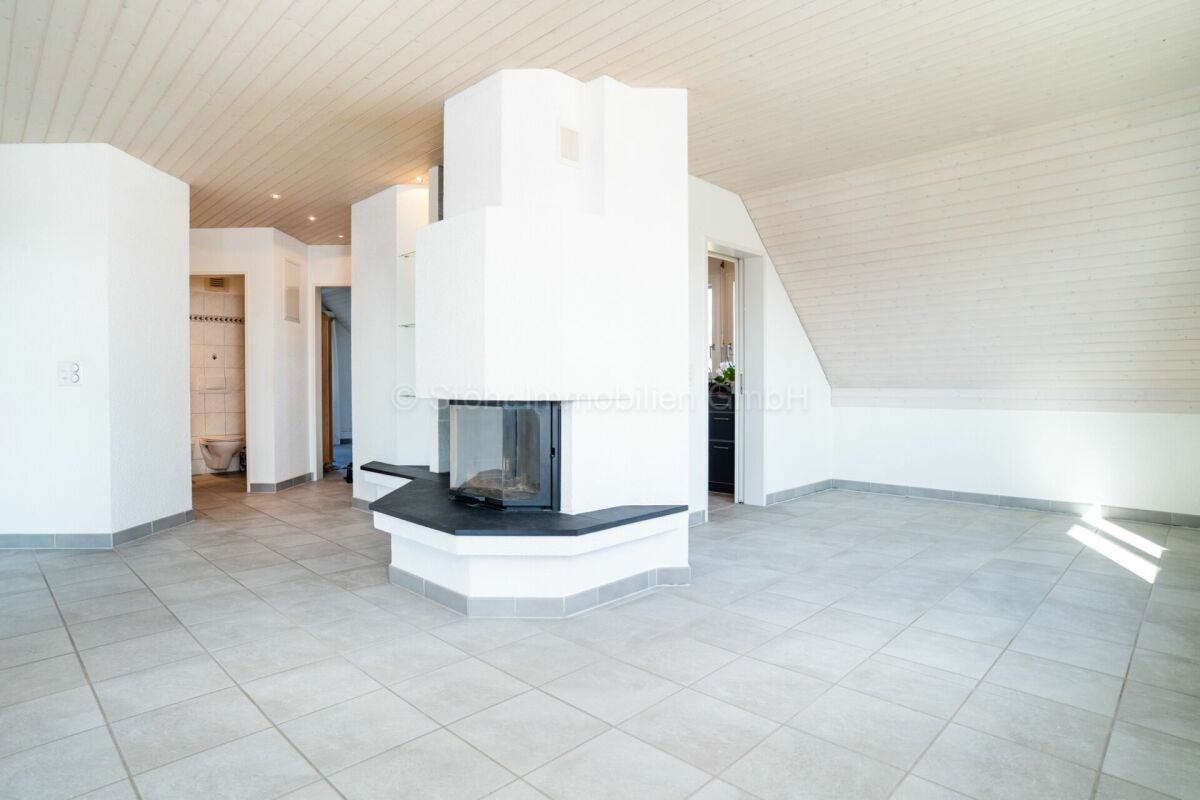 Heller Wohnraum mit Kamin und Dachschräge
