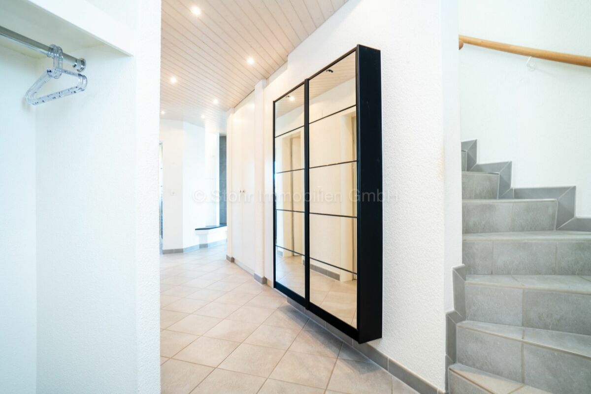 Heller Flur mit Treppe und Einbauschrank