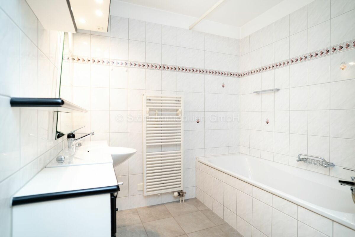 Helles Badezimmer mit Wanne und Wandfliesen