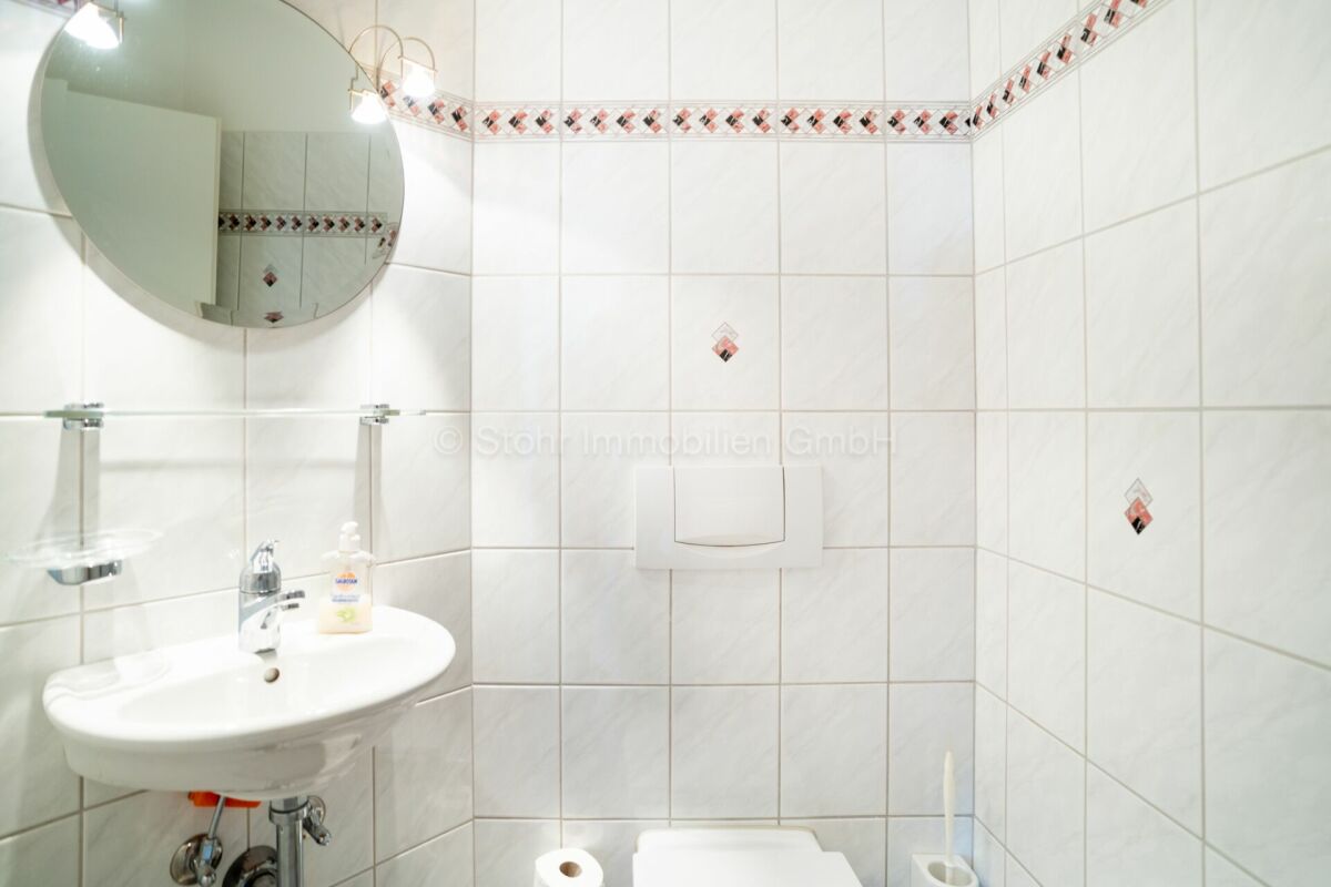 Kleines, weiß gefliestes Gäste-WC
