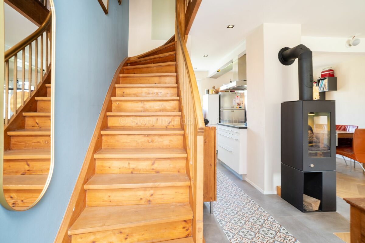 Treppenhaus mit Holztreppe und Ofen