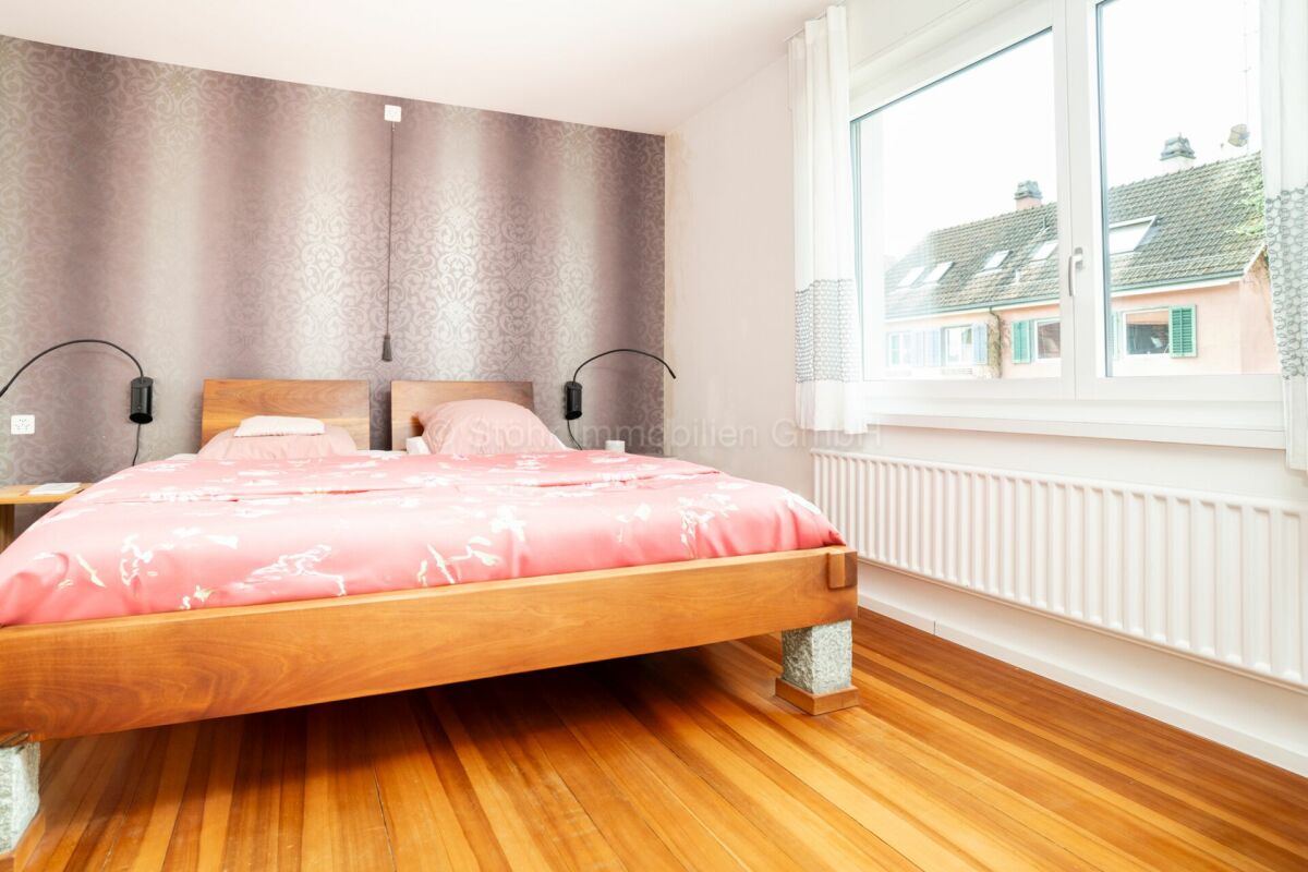Helles Schlafzimmer mit Doppelbett und großem Fenster