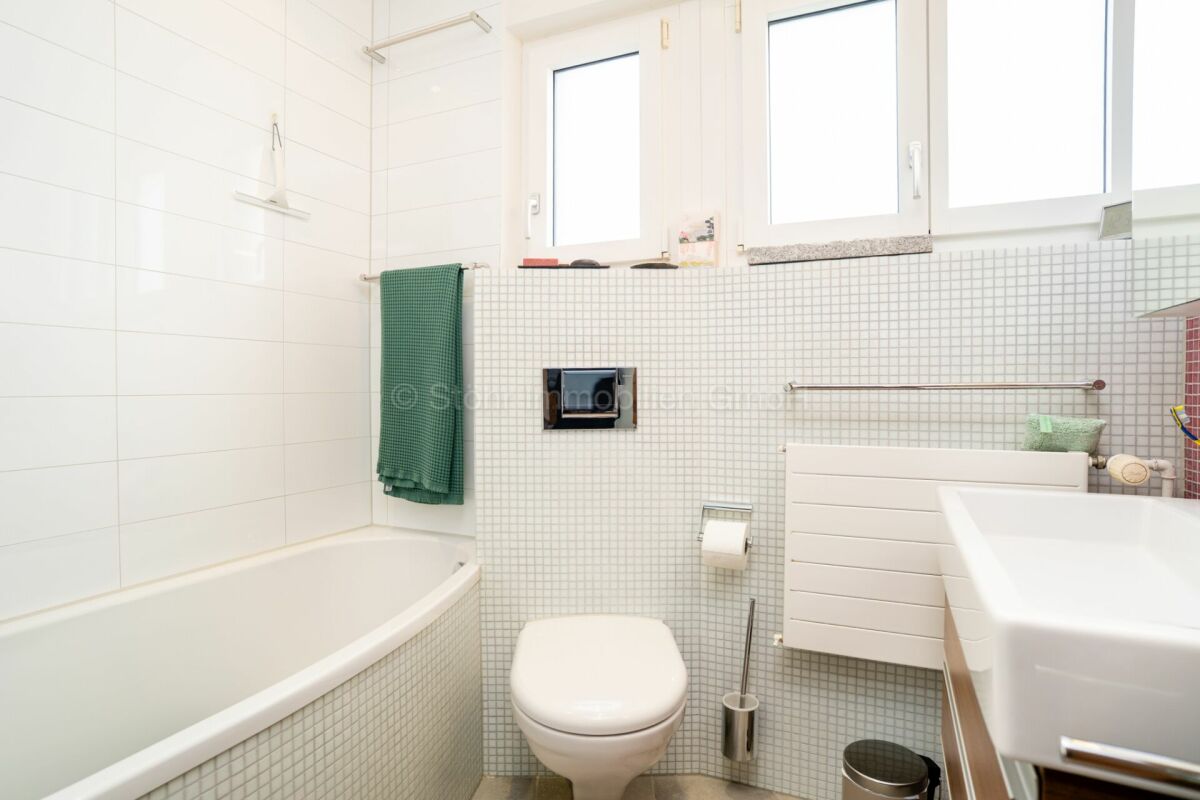 Modernes Badezimmer mit Badewanne und Fensterband